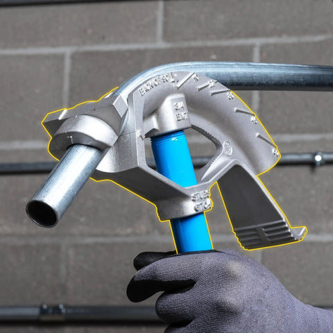 Heavy Duty 3/4 Inch Emt Electrical Conduit Bender By Ideal held in hand with blue handle, showing heat treated bending head, on gray wall.