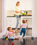 Two babies play near an 11 Inch White Baby Gate Extension For Easy Close Metal, Auto Close Metal, Safe Step With Trip Guard, It Fits And Click Lock Gates.