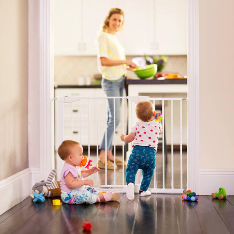 Two babies play near an 11 Inch White Baby Gate Extension For Easy Close Metal, Auto Close Metal, Safe Step With Trip Guard, It Fits And Click Lock Gates.