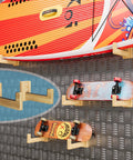 Rugged Wood Surfboard Wall Rack For Indoor Or Outdoor Use shown holding surfboards and skateboards, mountable with rubber pads.