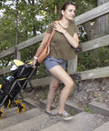 Woman using a Heavy Duty Wheeled Cart For Everyday Hauls And Quick Moves on steps, showcasing its all-terrain wheels.