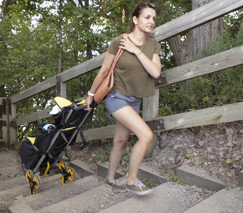 Woman using a Heavy Duty Wheeled Cart For Everyday Hauls And Quick Moves on steps, showcasing its all-terrain wheels.