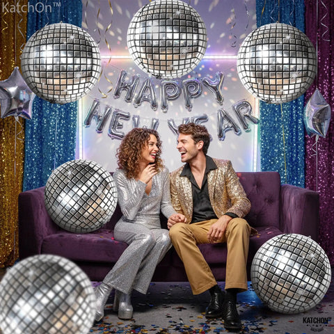 Showstopping 22 Inch Silver Disco Balloons Pack of 6 4D Sphere Balloons for Disco Party Decorations Retro 70s Theme Birthday Anniversary Decor and Photo Backdrops for Lit Party Vibes displayed over a couple on a sofa.