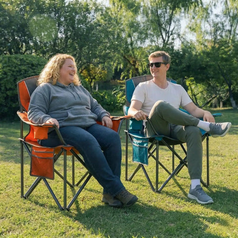 Two Pack Padded Oversized Camping Chairs For Adults With Cup Holder Cooler Bag And Side Pocket Folding Portable Lawn Chairs For Outdoor Picnics And Hiking Built Tough Heavy Duty Support Up To 400 Lbs Orange And Blue in use outdoors