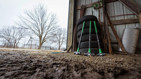 Three 16 lb sledge hammers with beefy heavy duty build, no slip H grip handle, fiberglass core, epoxy sealed head, leaning on tires.