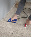 Installing carpet using Cool Shield Heat Bond Iron Pro Grade with Double Heat Shield and adjustable thermostat visible on beige carpet.
