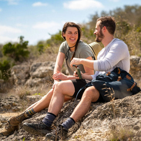 Two hikers resting on rocks with 8 Ounce Wide Mouth Stainless Steel Flask With Leakproof Hinge Cap Insulated And BPA Free