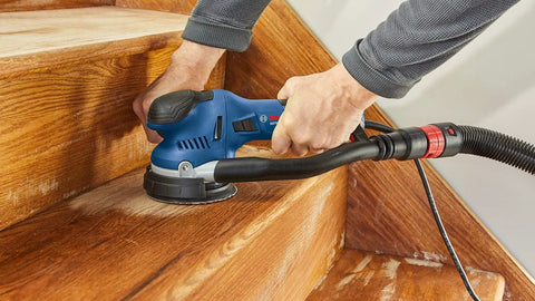 Using 5 In Hard Hook-and-Loop Sanding Pad With Multi-Hole Dust Extraction on wooden stairs for varnish removal and between-coats sanding