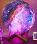 7.9 Inch Large Moon Lamp With Galaxy Starry Surface, 16 Color Modes, Remote Control And Touch Sensor glowing on wood stand