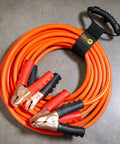 Assorted Three Pack Heavy Duty Easy Carry Straps With Built In Handle For Garden Hose Extension Cords Cables And Gear Organization In The Garage Boat And RV Great For Garden Tools Cords Hoses Power Cables And All Your Garage Boat And RV Organization Needs wrapped around orange jumper cables with plastic grips and copper clamps.