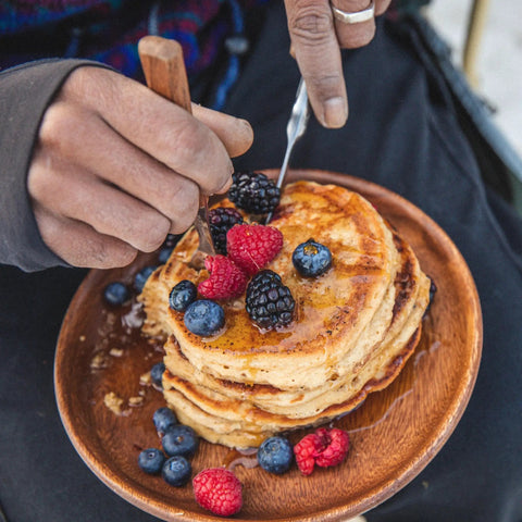 Person enjoying pancakes with berries, showcasing Protein Pancake Power Cakes Buttermilk Mix Pack Of 6 Non GMO Flapjack And Waffle Breakfast Mix Made With Whole Wheat And Oat Flours Delivers 14g Protein Per Serving For Quick Strong Start.