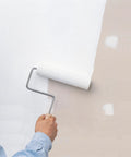 Person painting a wall with White Interior Water Base Primer And Sealer Locks In Stubborn Stains On Walls Doors Trim And Concrete Fast Drying Low Odor Formula.