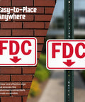 Rugged 12X18 Inch Fdc Fire Department Connection Metal Sign With Down Arrow In Red And White on brick and pole backgrounds.