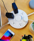 Six Outlet Surge Protector With USB Charging Station 1080 Joules 6 Ft Cord on desk, devices plugged in