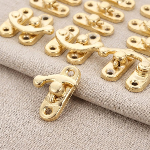 Retro Vintage Swing Bag Clasp Closure Lock Latch for Furniture and Wooden Boxes in antique gold finish on fabric background.