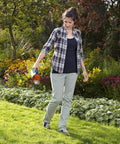 Woman using Compact Hand Spreader And Grit Container For Sand Salt And Grit Easy Winter Spreading With 3 Setting Dose System