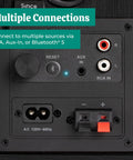 Back panel of powered bookshelf speakers with built-in amplifier, showing RCA, Aux, and Bluetooth 5 connections.
