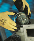 Hands wearing HyFlex 11-500 Kevlar Cut-Resistant Work Glove With Foam Nitrile Grip handling metal part, X-Large Size 10