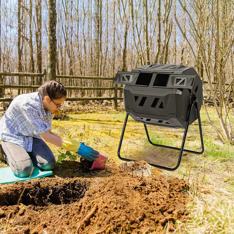 Person gardening next to Dual Chamber Outdoor Compost Tumbler With 43 Gallons Capacity 360 Degree Rotating Barrel for composting.
