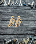 4Pcs Brass Double Ball Tension Roller Door Catch Hardware Set on wooden surface with tools, Adjustable 50mm Latch