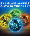 Four glow-in-the-dark glass marbles from the Glowing Marble Run Kit With 15 Glow-In-The-Dark Glass Marbles And Storage Bag.