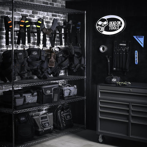 Garage storage with various tool bags including 18 Inch FlatTop Weather Resistant Tool Bag With All Terrain Bottom And Weatherproof Front Pocket 12 Interior Pockets Removable Padded Shoulder Strap Gray Assembled In The USA displayed on shelves.