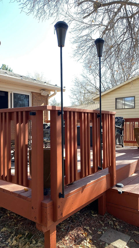 Tiki Torch Deck Or Fence Mount Kit Black For Three Quarter Inch And One Inch Poles on wooden deck railing, installed setup