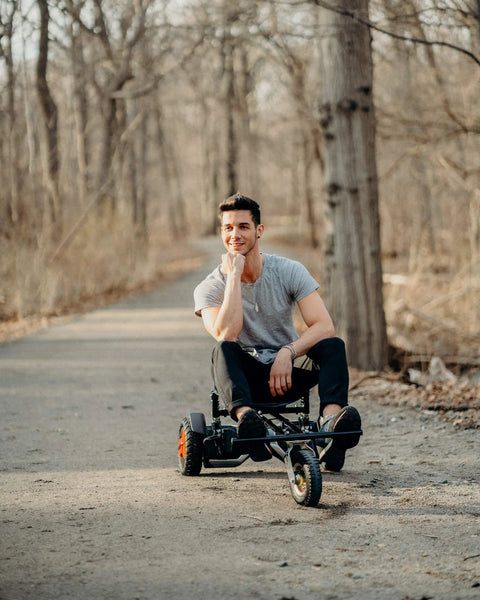 Person seated on Beast Buggy Go Kart Attachment For 10 Inch Hoverboards With Hand Operated Rear Wheel Control on a path.