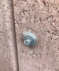 Close-up of a 50 Piece Hella Durable Trellis Anchor against stucco surface, designed for climbing vines and LED light strips.