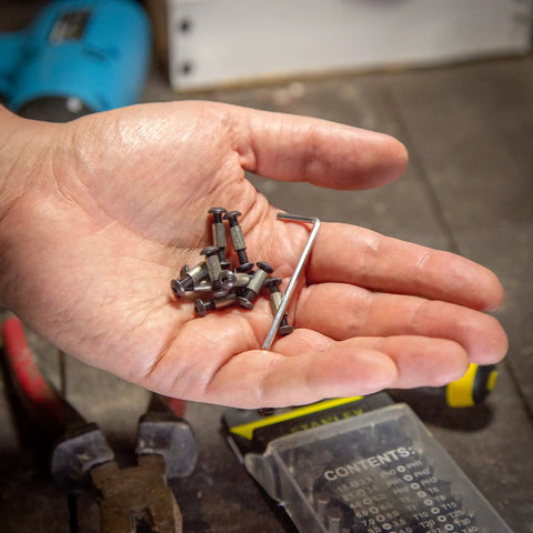 Hand holding 10 Pack Handle Screws, Rivets, Bolts, And Fasteners With Hex Key For DIY Knife Making And Fixed Blade Repairs.