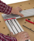 Hands adjusting Dead On Heavy Duty Adjustable Variable Router Jig Kit 18X32 Inch Base on a workbench for precise cuts.