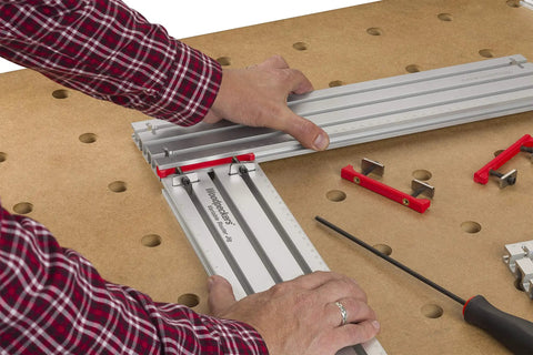Hands adjusting Dead On Heavy Duty Adjustable Variable Router Jig Kit 18X32 Inch Base on a workbench for precise cuts.