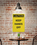 Keep Hands Clear Caution Sign 8x12 Aluminum UV Safety Plaque displayed against a brick wall under a hanging light, above a table.
