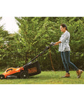 Person using Corded Electric Push Lawn Mower With 13 Amp Motor, 20-Inch Deck, 6-Position Height Adjustment in garden