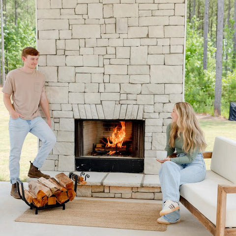 Curved 24.5 Inch Firewood Rack With Kindling Hooks for Indoor Use, by outdoor fireplace, logs neatly stacked on rack.