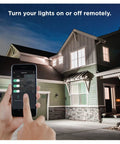 Person using smartphone app to control Zigbee A19 Daylight LED Light Bulbs, 8 Pack, from outside house at night.