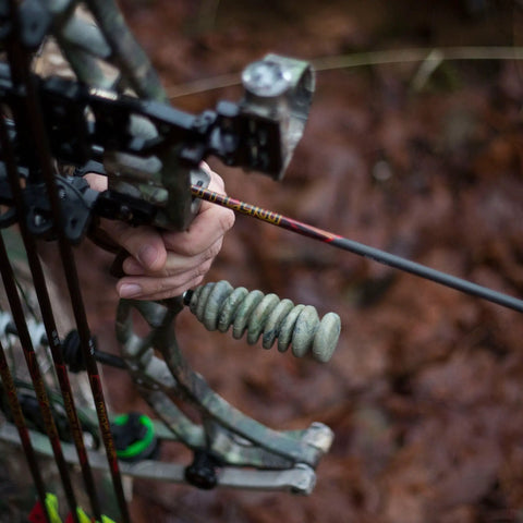 Archery setup featuring S-Coil Bow Stabilizer 4.5 Inch NAVCOM Vibration Dampening in use, camo finish, close-up view.