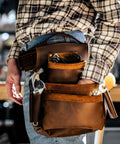 Genuine Leather Tool Belt For Men With Pouches And Boss Grade Heavy Duty Saddle Design in use by worker holding tools