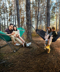 Two people relaxing in green and black Combo Hammocks With Stand For Outdoor And Indoor Use, Heavy Duty 600 Lbs Capacity, 2 Person Set