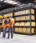 Workers examining sturdy 71 inch heavy duty garage shelving unit with 2050 lb capacity in industrial warehouse setting.