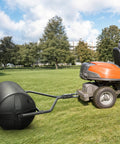 18 Inch By 24 Inch Poly Lawn Roller With Threaded Plug, 270 Lb Capacity, Push Or Tow Design, attached to lawn tractor in field