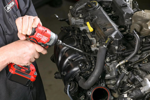 Mechanic using drill on car engine, illustrating use of Impact U Joint And Adapter Set For One Quarter, Three Eighths, And One Half Inch Drives With Two Adapters And Two Reducers, Beast Of A Heavy Duty Auto And Workshop Tool Kit For Hard To Reach Fasteners