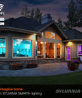 Smart home exterior with WiFi LED Smart Light Bulb BR30 65W Equivalent, showing full color and tunable white lighting indoors.