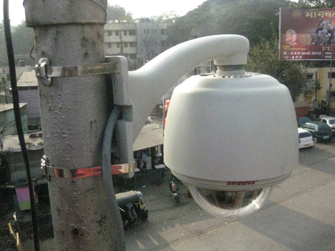 Outdoor surveillance camera mounted on a pole in a street setting using Heavy-Duty 201 Stainless Steel Band Roll for security and stabilization.