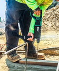 Person using Powerhouse Heavy Duty SDS Plus Rotary Hammer Drill One And One Eighth Inch 3 Mode at construction site.