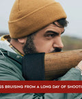 Man using Gel Recoil Pad For Shotguns And Rifles, Slip On Visco Elastic Gel Stock Pad Reducing Kick on wooden stock, outdoor setting.
