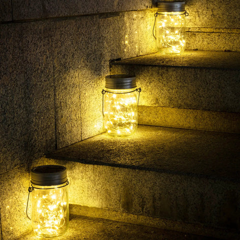 Hanging Mason Jar Solar Lights 6 Pack With 30 LED Lanterns illuminating stone steps outdoors, showcasing waterproof design.