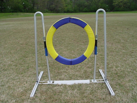 Pro Grade Durable Dog Agility Tire Jump With Non Rust Aluminum Frame For Smooth Quick Reset On Impact Outdoor Field Ready Training Gear For Competitive Courses And Home Practice, yellow and blue tire on grass field.