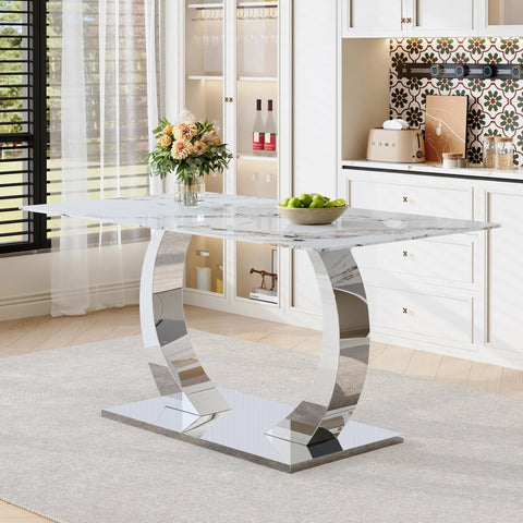 Elegant dining table with marble top and curved metal legs in a modern kitchen setting, flowers and fruit bowl on top