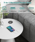 Flush Mount Desk Power Grommet With Two Outlet Jacks And Four USB Ports Including Dual PD Fast Chargers Plus HDMI Connectivity And A Low Profile Plug For Office Desks And Cabinets A Straight Up Game Changer For Slick Workspace Organization on a white table with a phone charging.